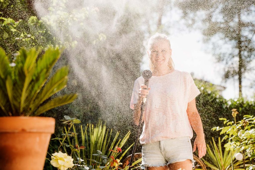 Woman Spraying Water Outside